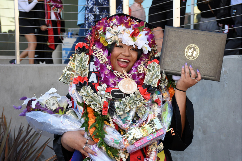 Girl with her diploma holder and money lei 